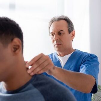 Pacientam ar kakla sāpēm ārsts veic diagnostisko izmeklēšanu.